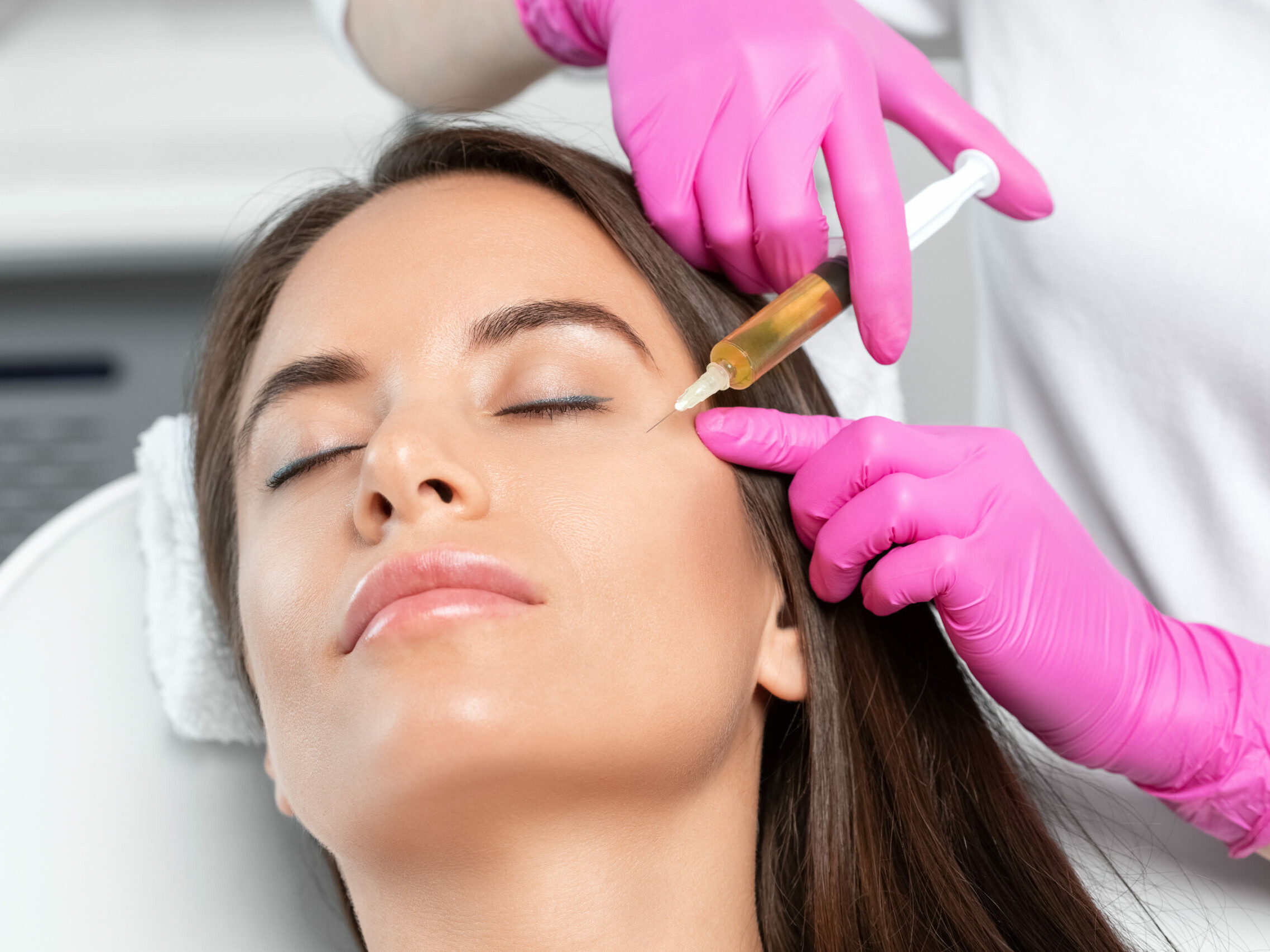 Cosmetologist does prp therapy on the face of a beautiful woman in a beauty salon. Women's cosmetology in the beauty salon.