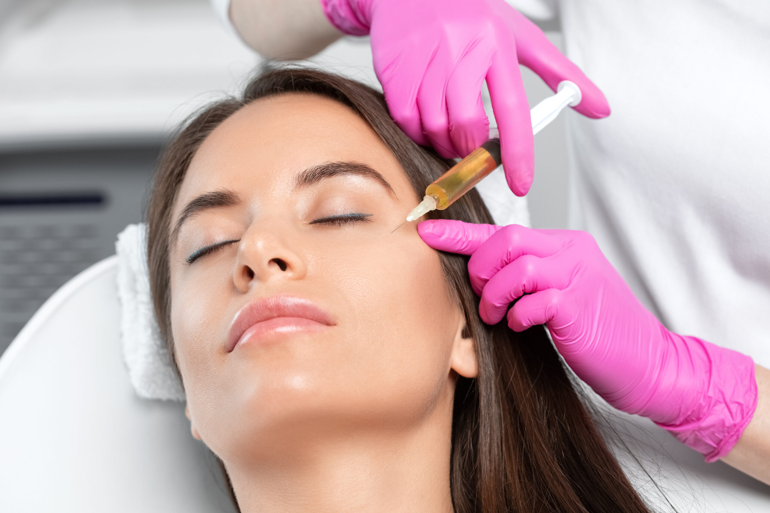 Cosmetologist does prp therapy on the face of a beautiful woman in a beauty salon. Women's cosmetology in the beauty salon.